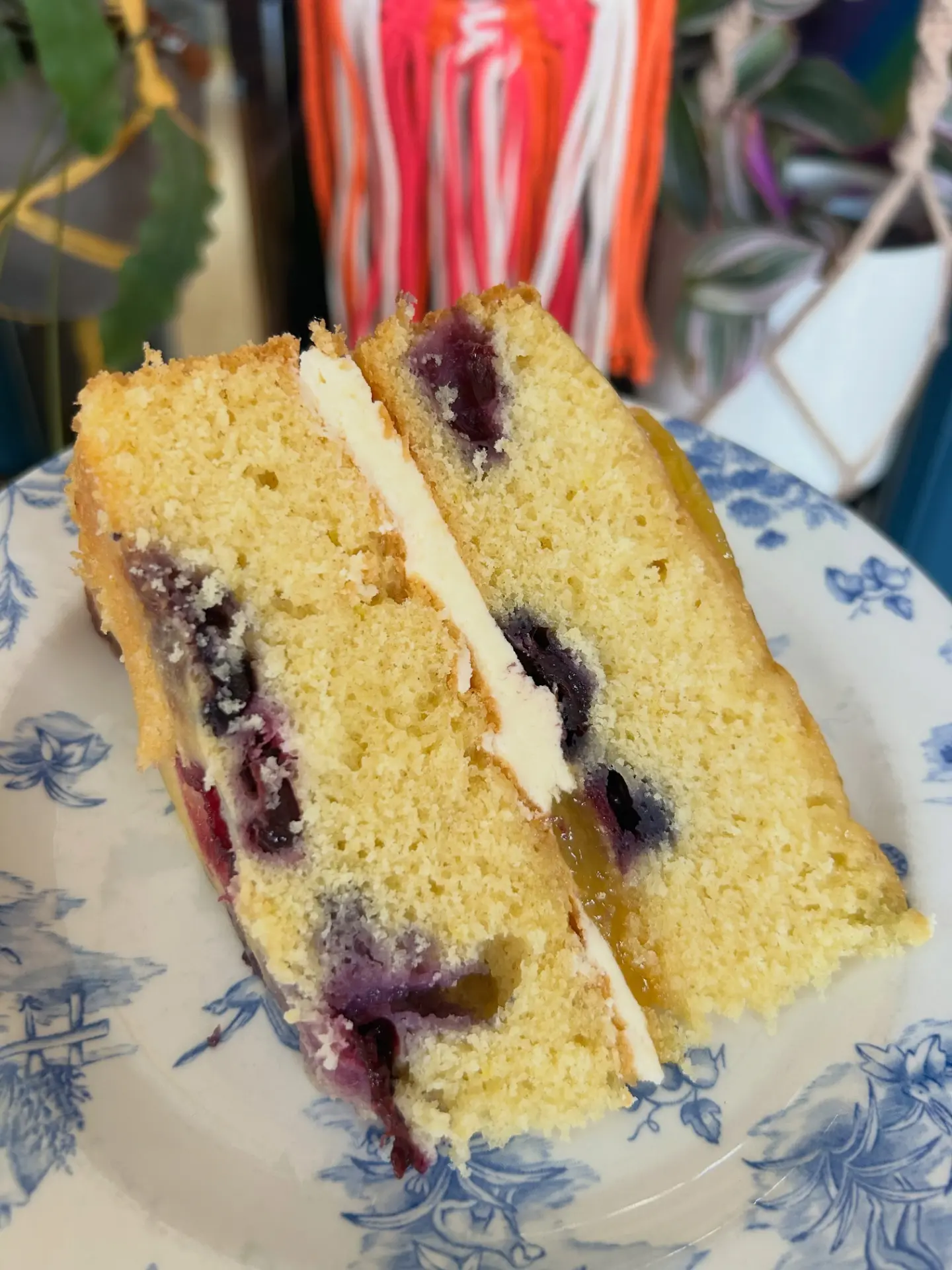 Slice of blueberry and lemon layer cake on a floral plate
